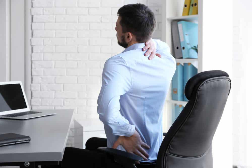 Hombre con dolor de espalda sentado en un despacho