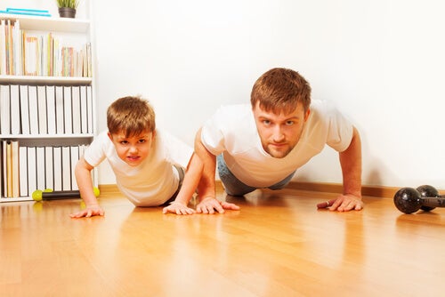 Padre practicando ejercicio con su hijo para promover el refuerzo positivo.