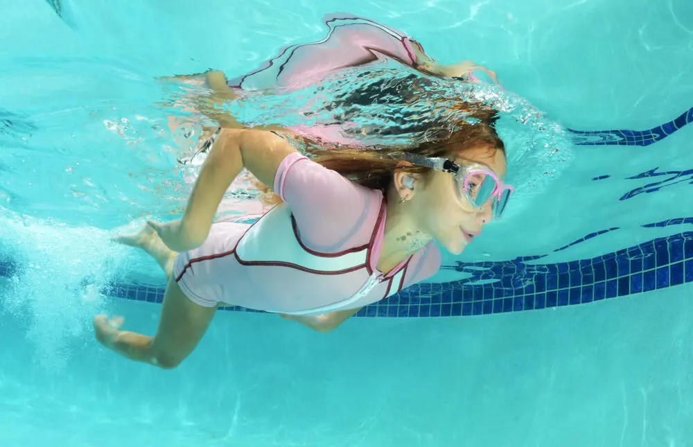 Niña nadando en la piscina