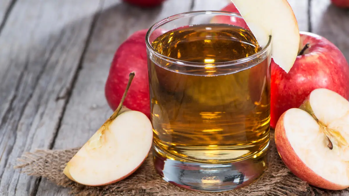 Jugo de manzana con agua de coco, con manzanas cortadas.