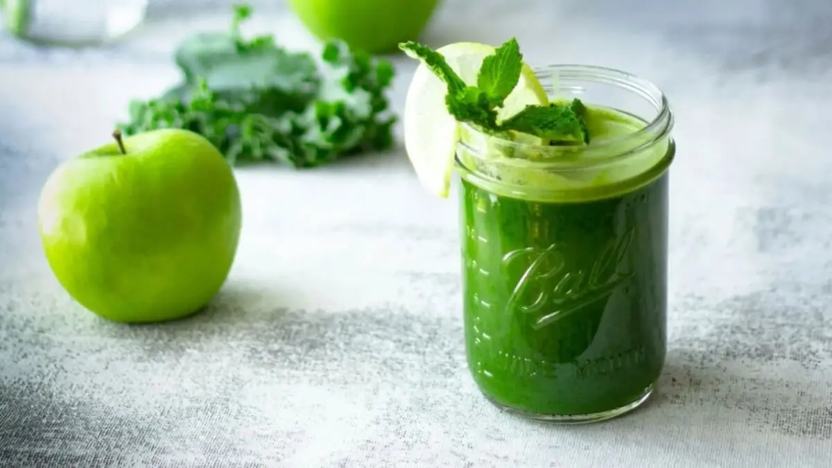 Jugo de manzana verde, apio y espinacas en un vaso.