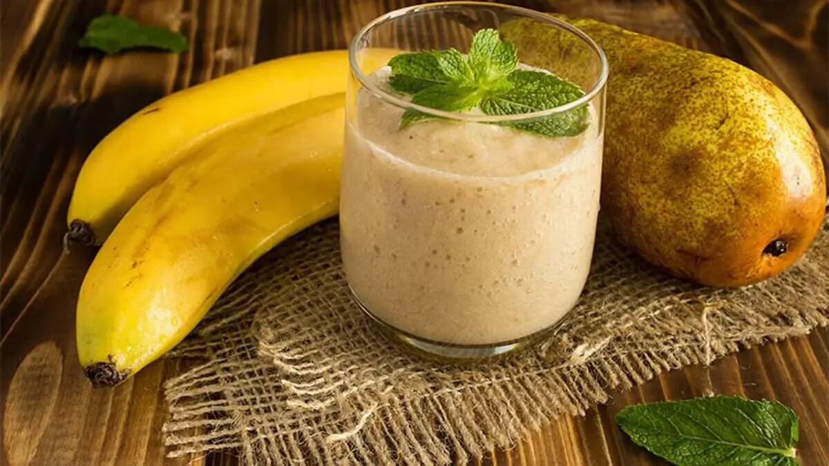 Jugo de plátano y pera, con dos cambures al lado.