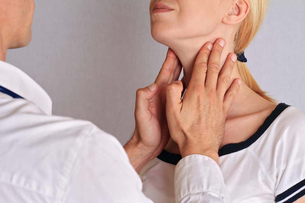 Cuello de mujer siendo palpado por un médico para el control de la tiroides.