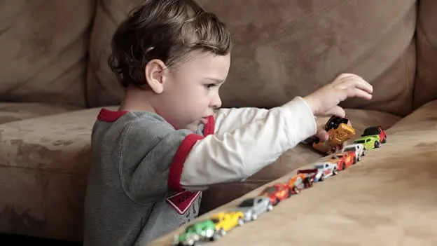 Niño jugando con coches.