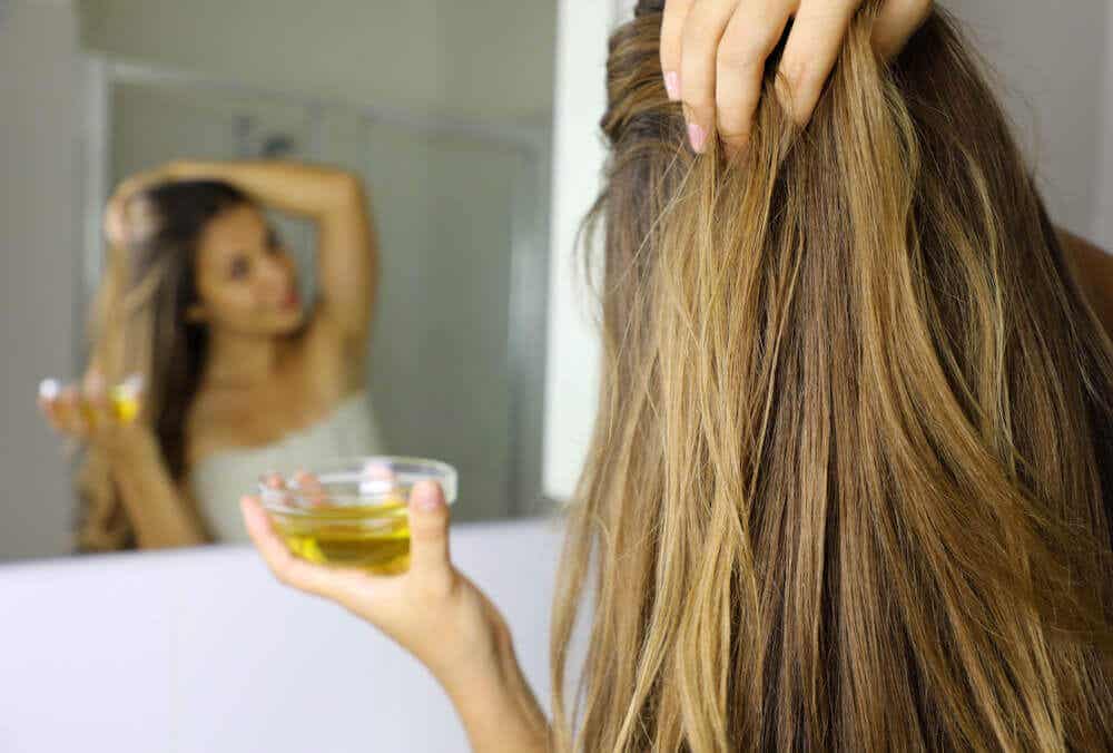 Chica aplicándose aceite en el cabello.