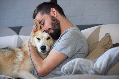 Chico abrazando a su perro en la cama.