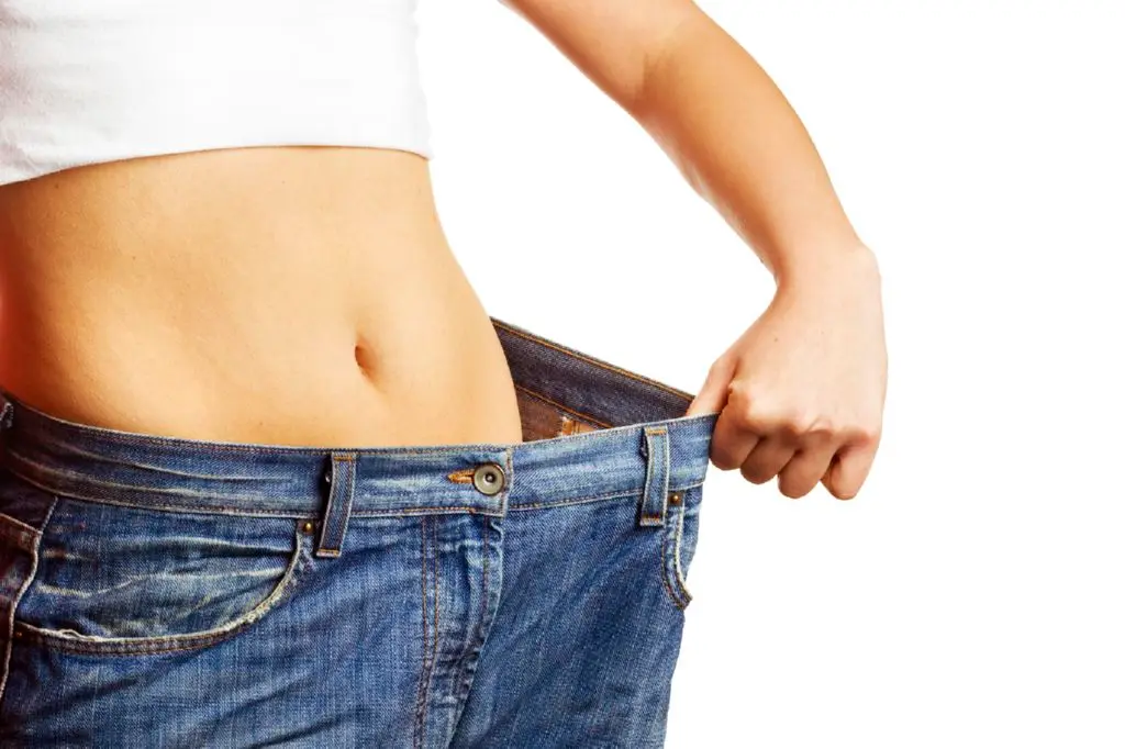 Woman showing how much weight she lost. Healthy lifestyles concept