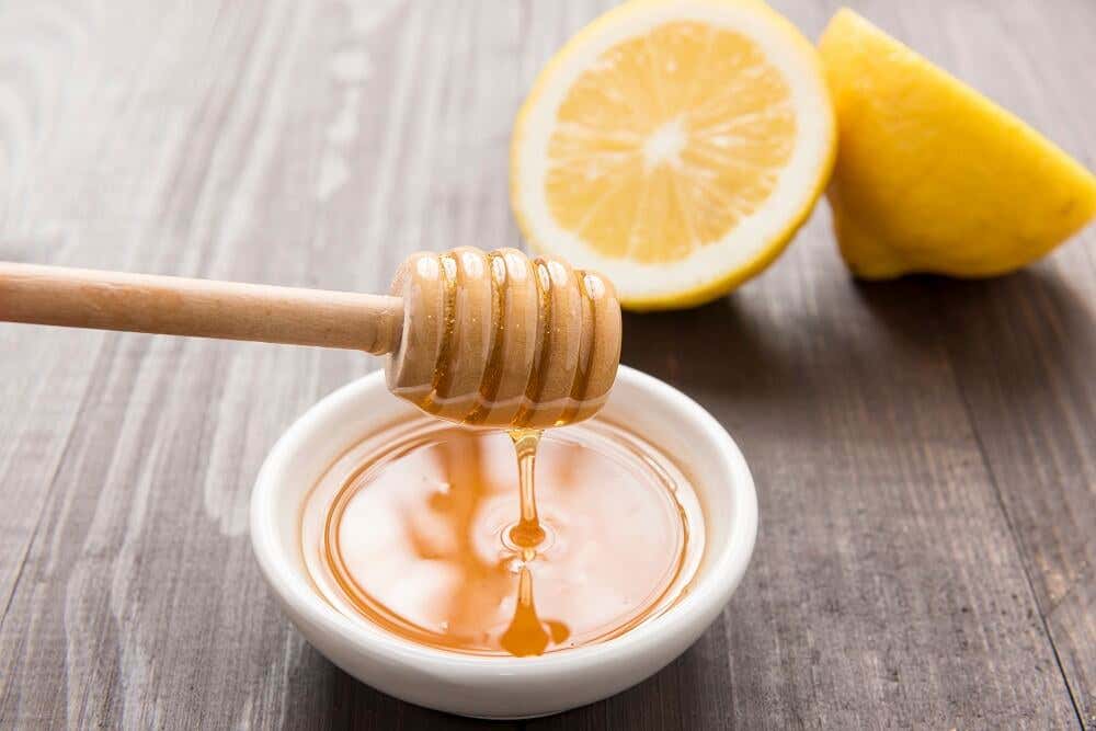 Bol de miel con limones frescos.