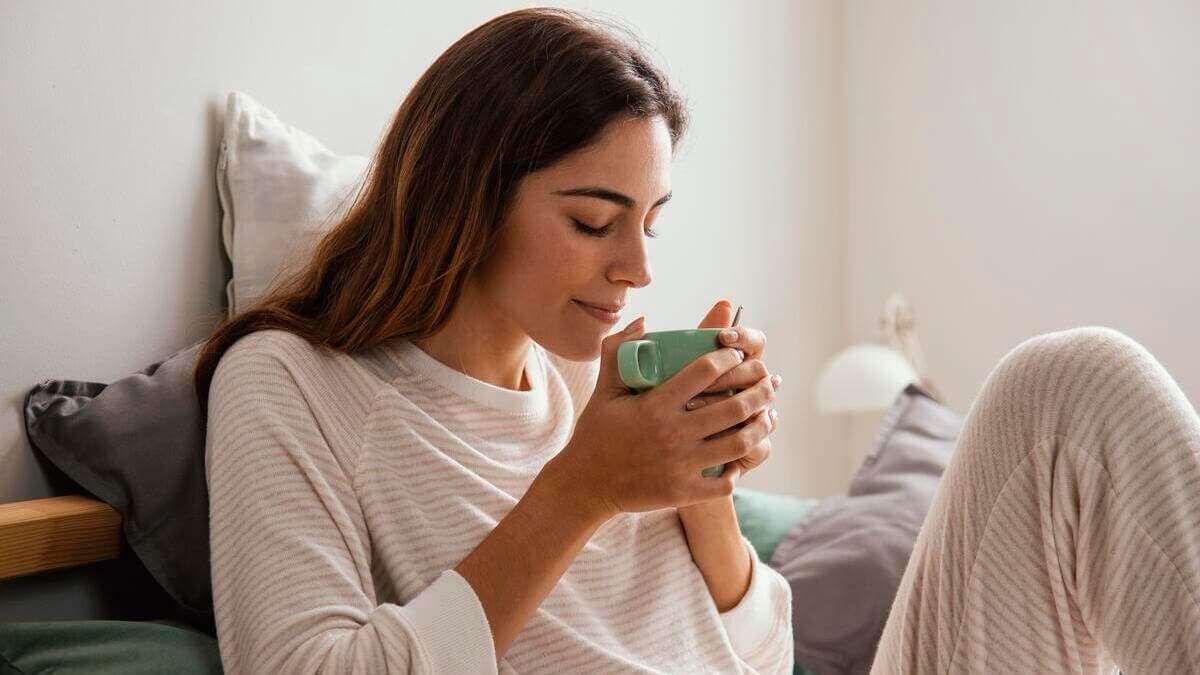 Mujer toma infusiones para cólicos menstruales.