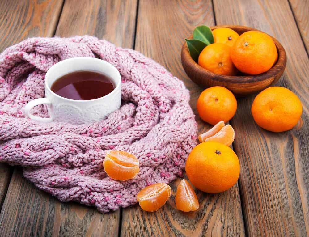51270705 - cup of tea with scarf and tangerines on a old wooden table