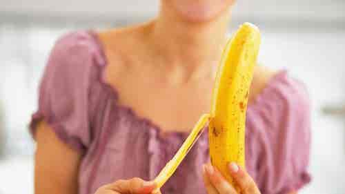 Mujer pelando un plátano