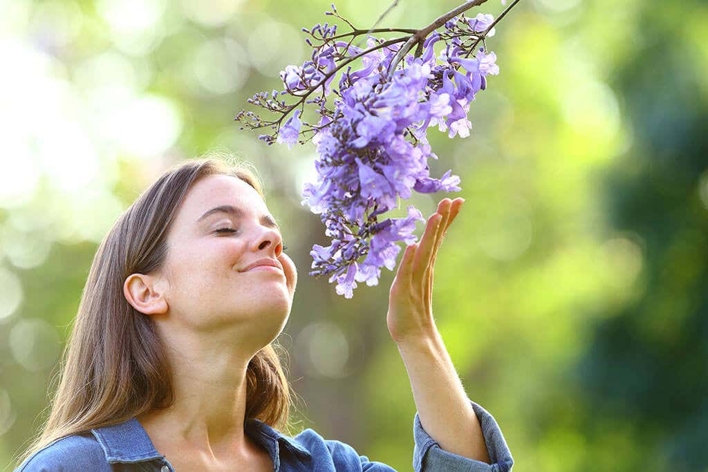 A woman smelling flowers.