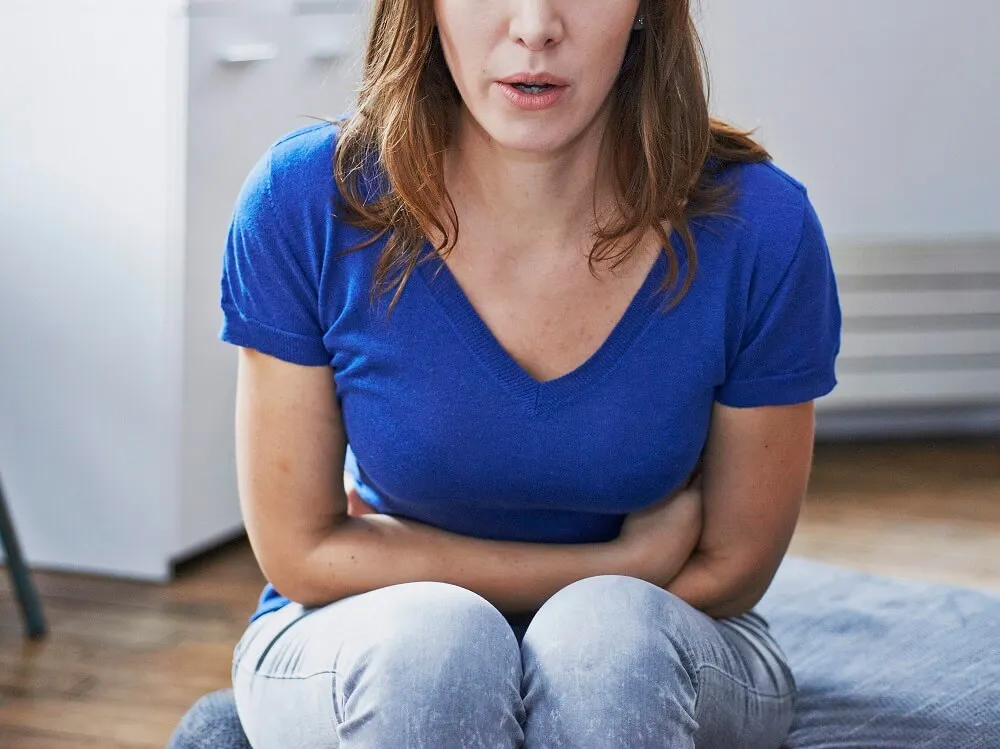 Woman suffering from abdominal pain. France