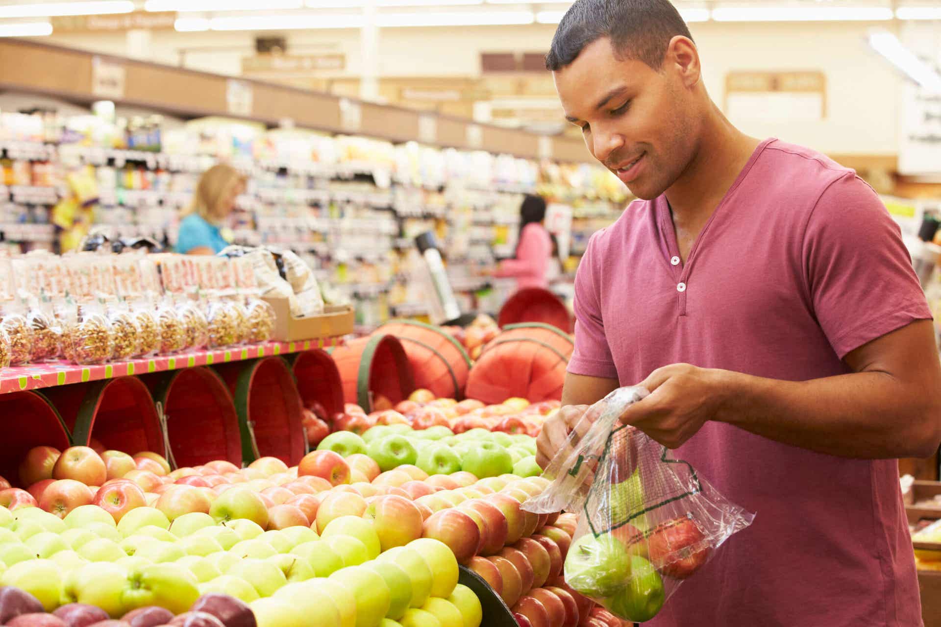 Hombre comprando fruta en el supermercado. 