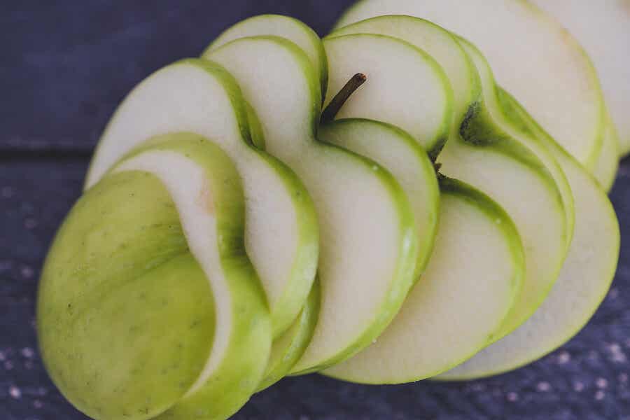 Manzana verde cortada en forma de corazones.