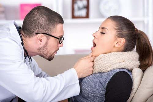Médico mirando la garganta de una mujer