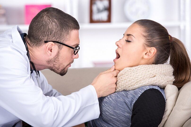 Médico evaluando paciente con estomatitis