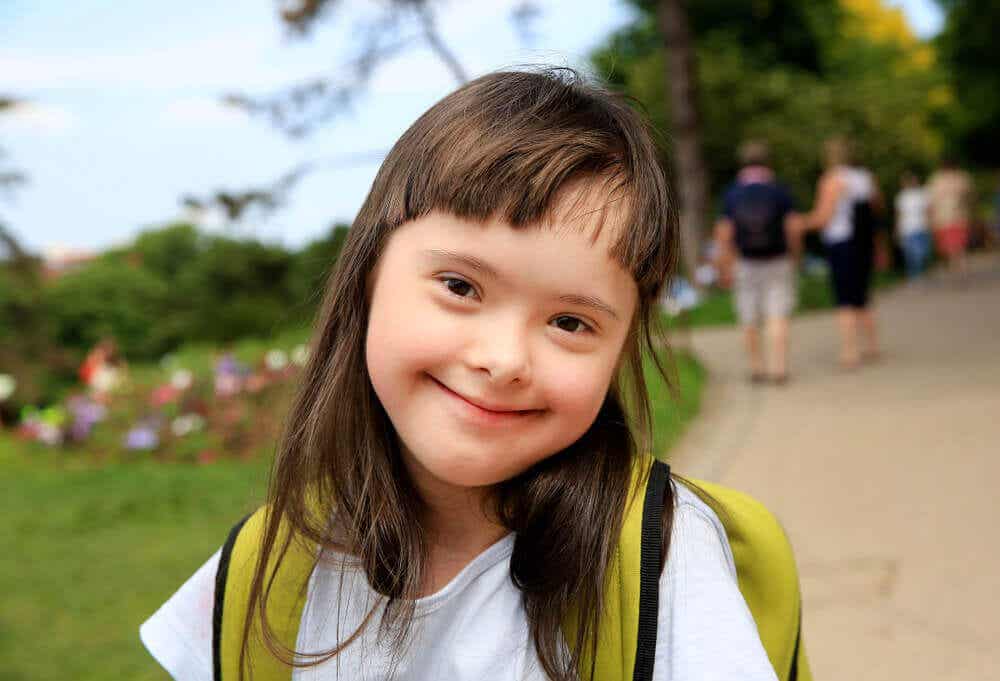 Niña con síndrome de Down con mochila para ir al colegio.