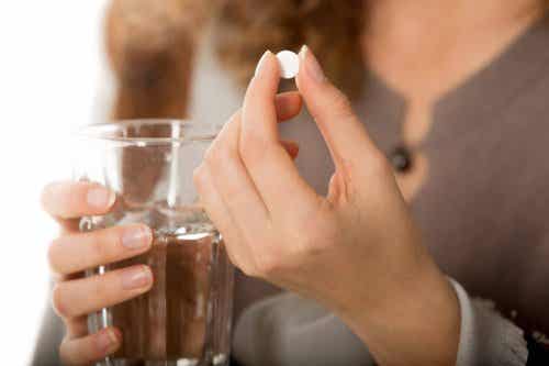 Mujer con una pastilla en la mano: controlar la enfermedad de Crohn