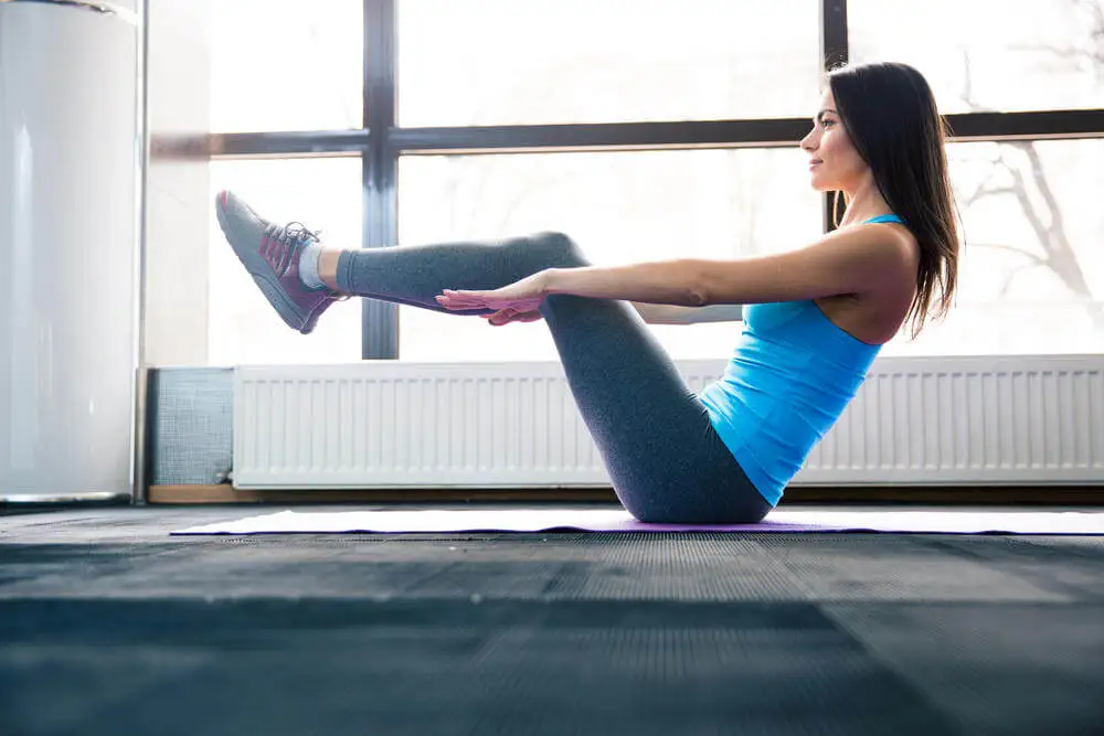 Postura del barco que se realiza en la práctica de yoga para trabajar los abdominales.
