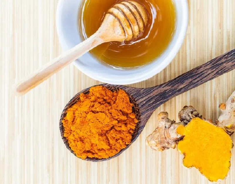 Polvo de cúrcuma y bote de miel.