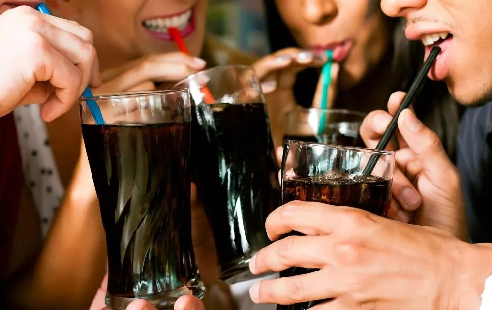 Chicos bebiendo refrescos de cola