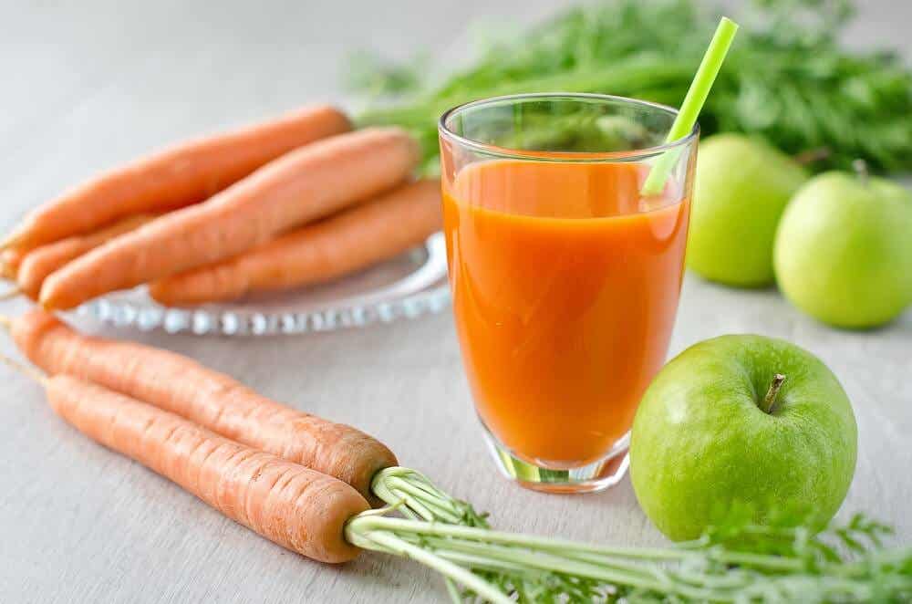 Healthy fresh carrot juice in a glass and green apples