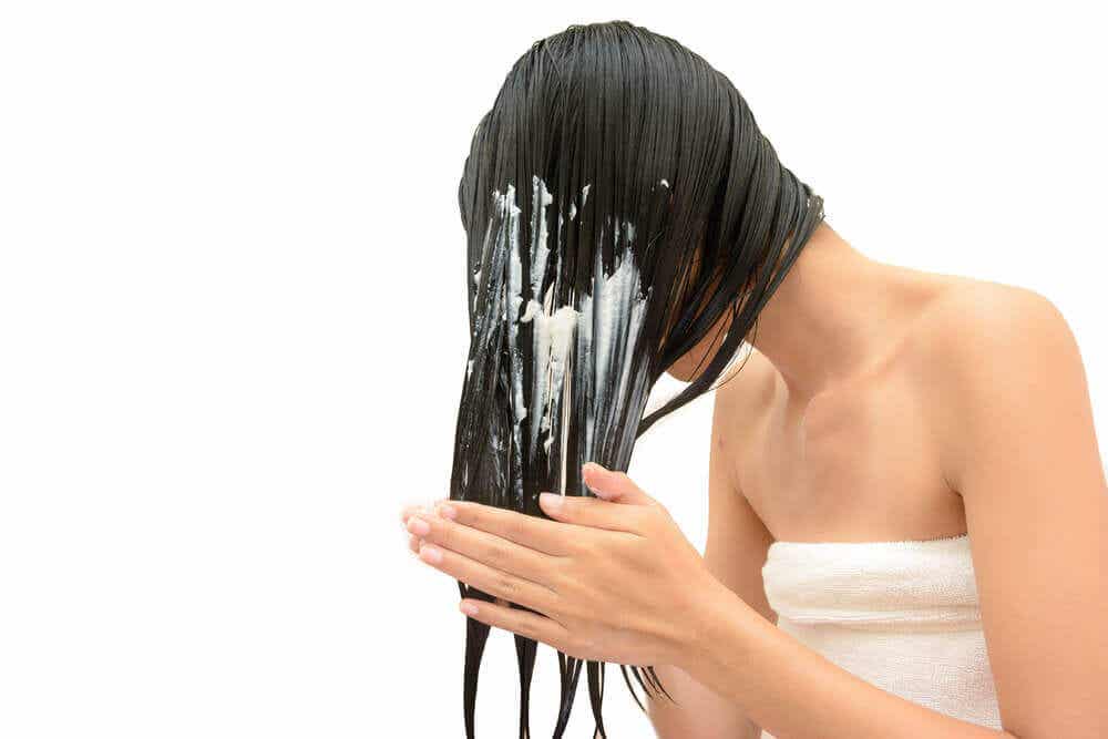 Mujer aplicándose una mascarilla en el cabello.