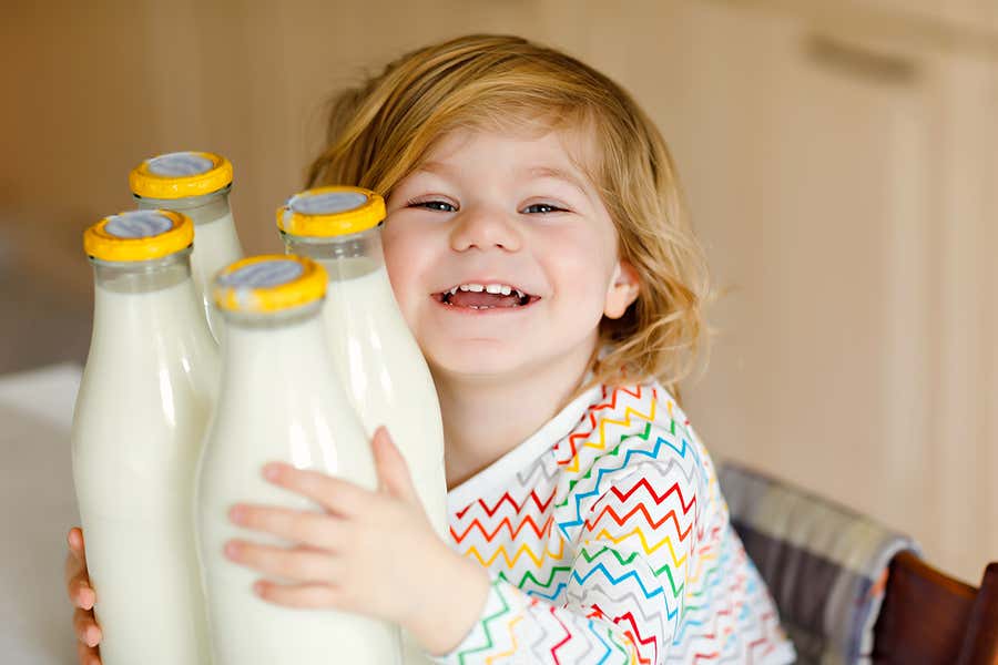 Niño con botes de leche.