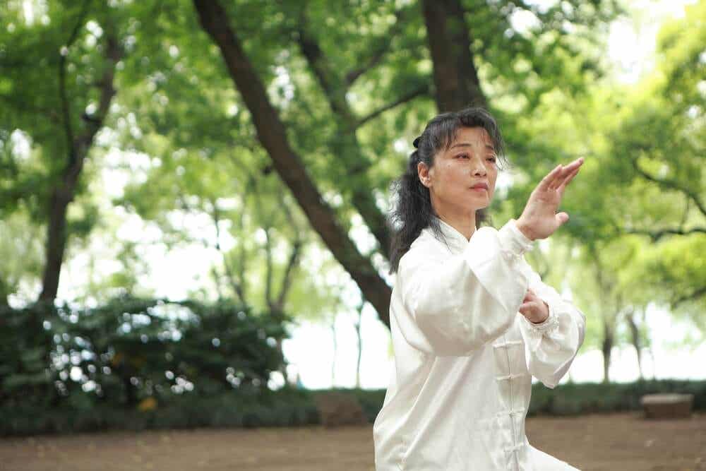 Mujer practicando taichí en un parque
