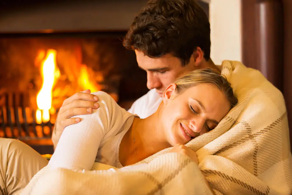 Pareja abrazada junto al fuego