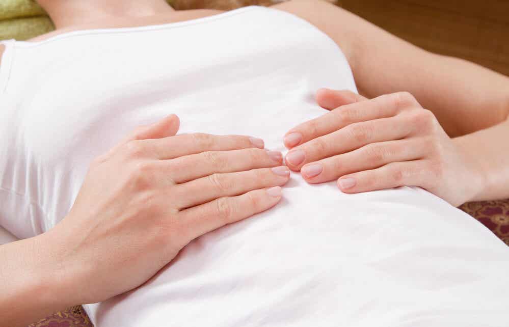 Hands of lying woman on her belly during massage