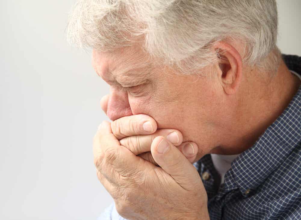 Hombre con náuseas como síntoma del cáncer de colon.