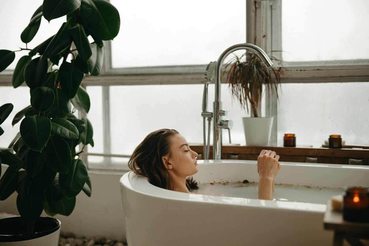 Mujer tomando un baño caliente para relajarse.