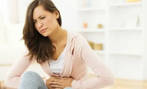 Mujer con gases intestinales y dolor estomacal.