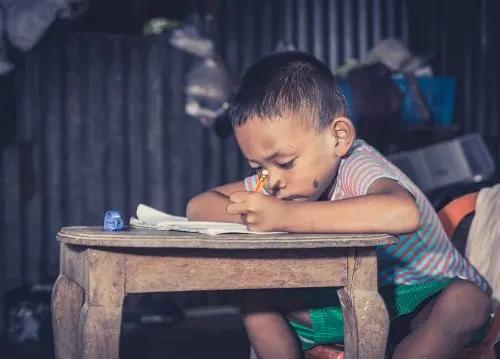 Niño pobre estudiando