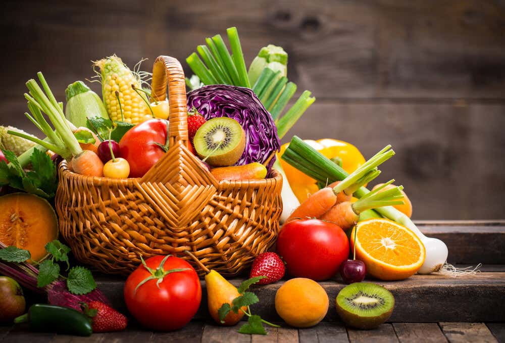 Cesta llena de alimentos saludables como verduras y frutas