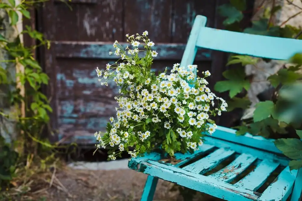 Silla de madera azul con flores.