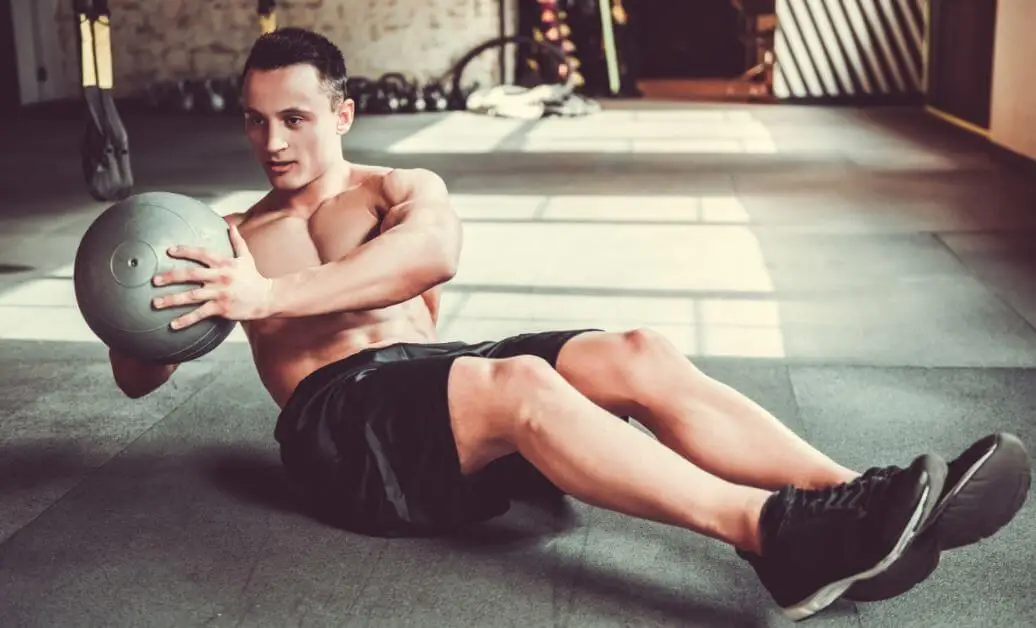 Funktionelles Muskeltraining - Mann mit einem Medizinball