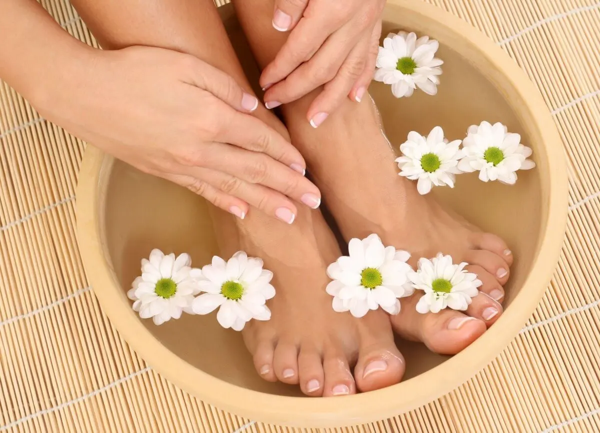 Mujer dándose un baño de pies con agua y sal.