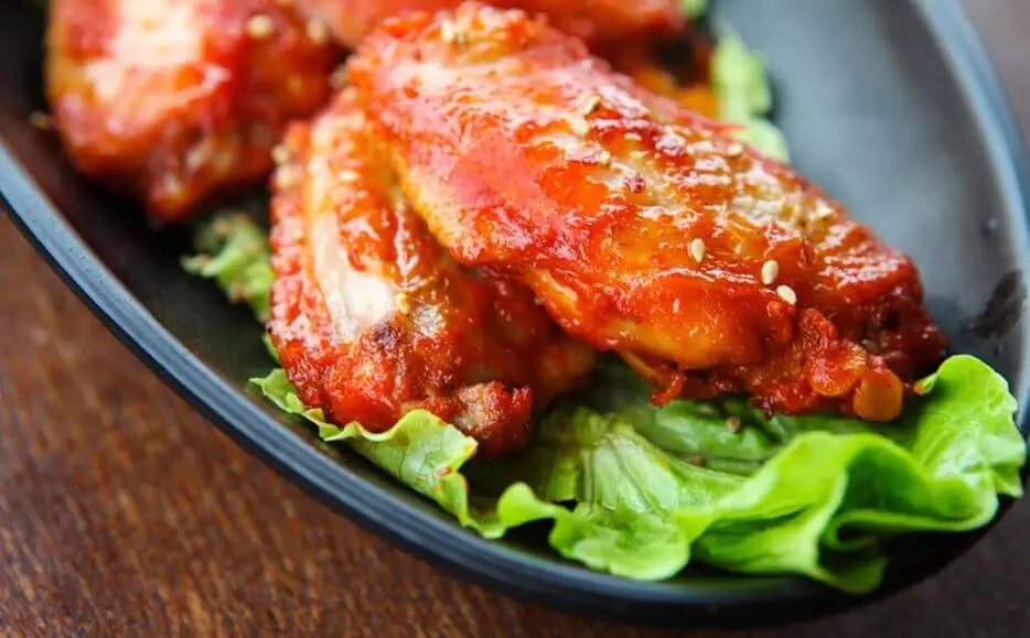 Alitas de pollo con salsa y lechuga.