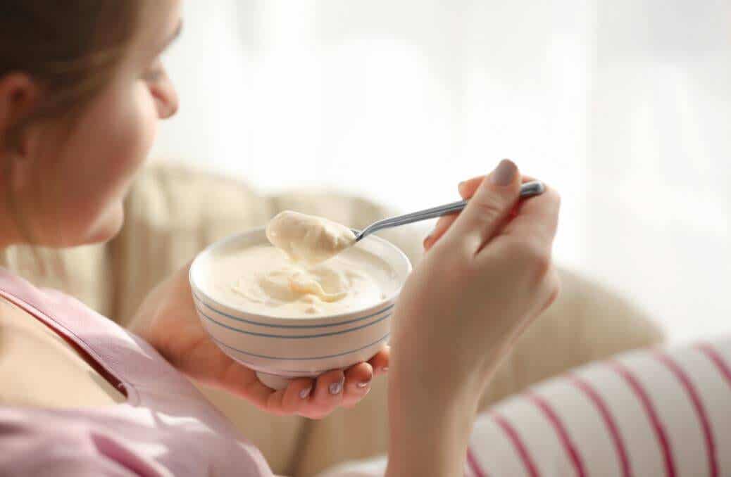 Donna che mangia yogurt con il melone