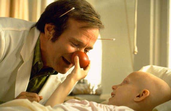 Fotograma de la película Pach Adams niño rie junto al doctor con nariz de payaso. afrontando las dificultades