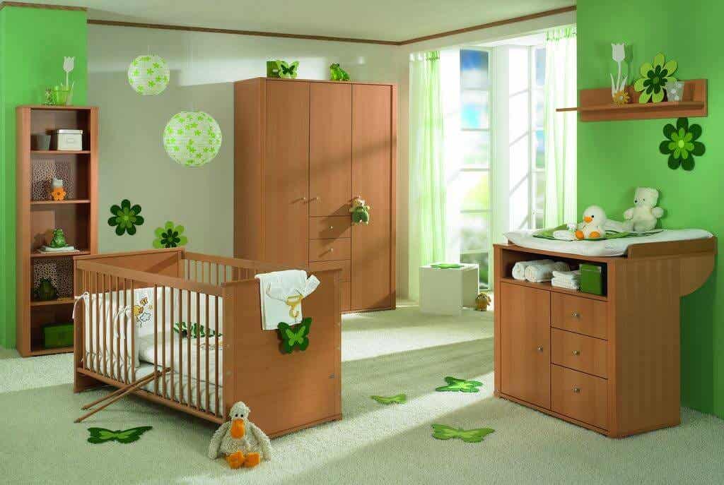 Habitación de bebé decorada con tonalidades verdes y muebles de madera.