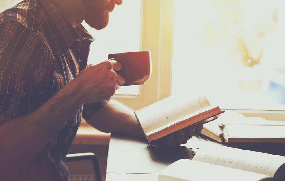 Hombre leyendo y bebiendo café.