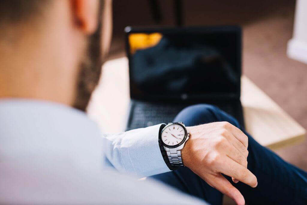 Hombre mirando reloj de pulsera.