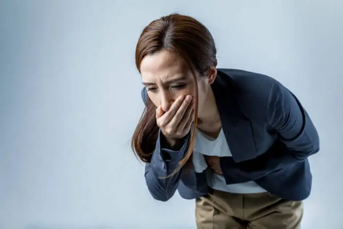 Mujer con cara de vomitar.