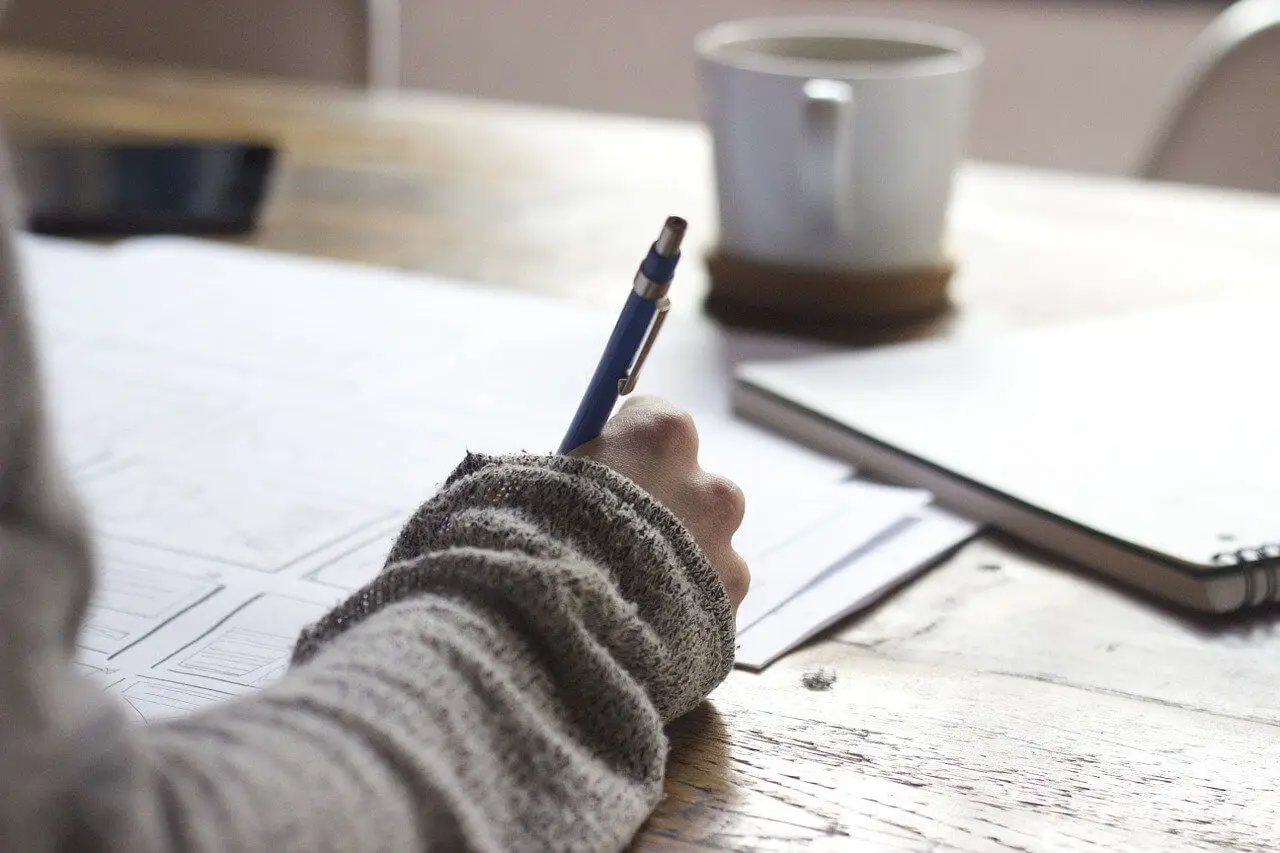 Mujer escribiendo propósitos en una libreta.