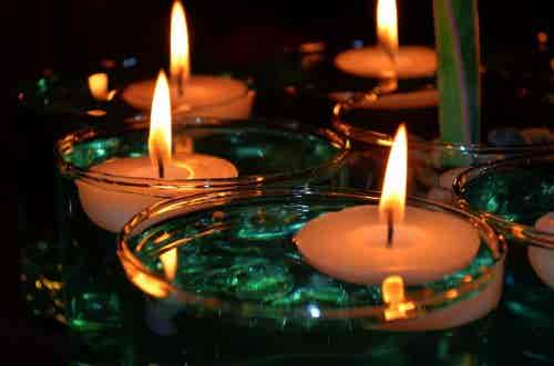 Mesa decorada con velas flotantes en agua.