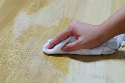 Persona encerando el suelo de madera.